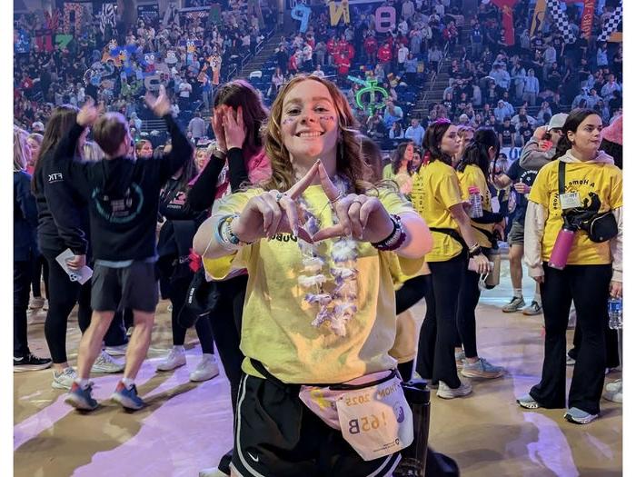 Penn State DuBois student Amber Eberly stands on the dancefloor at the Bryce Jordan Center during THON 2025.